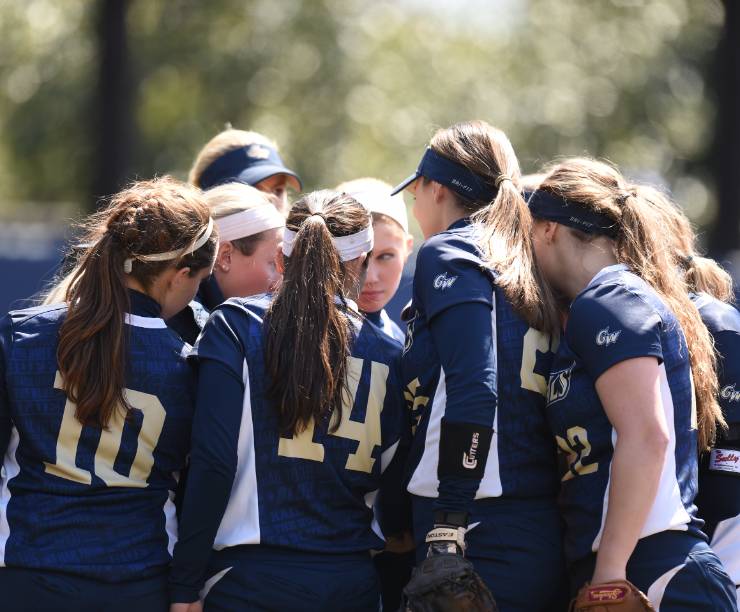 A group of players in uniform stand in a huddle.