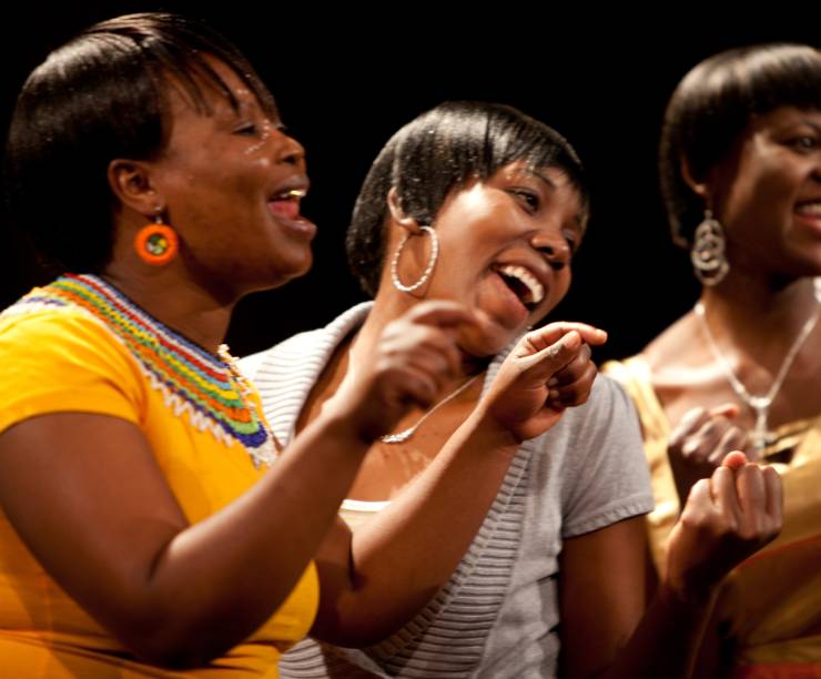 Three young South African women sing together.