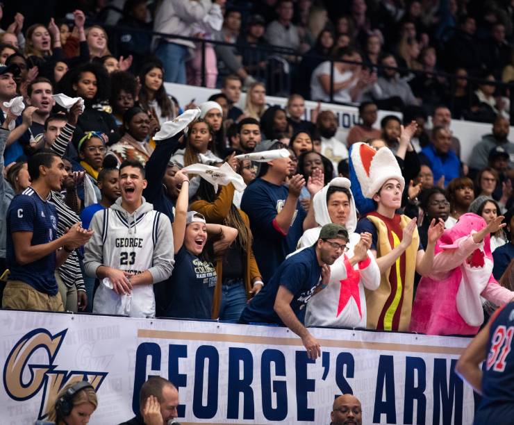 Students in GW t-shirts cheer from the stands.