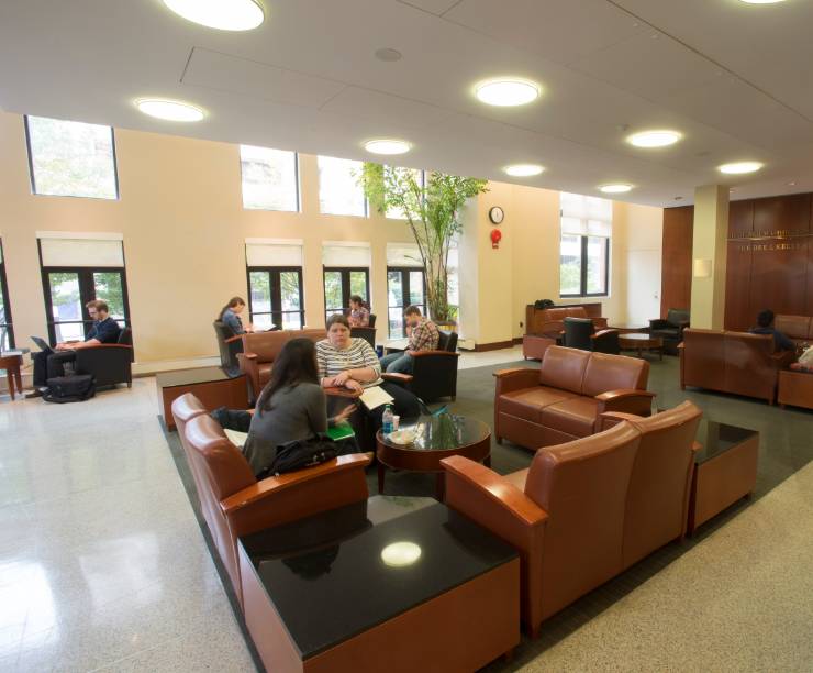 Students seated on leather couches and chairs in GW Law's Kelly Lounge.