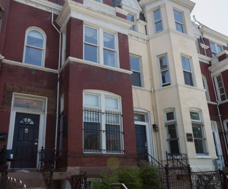 A view of the front doors of several brick townhouses.