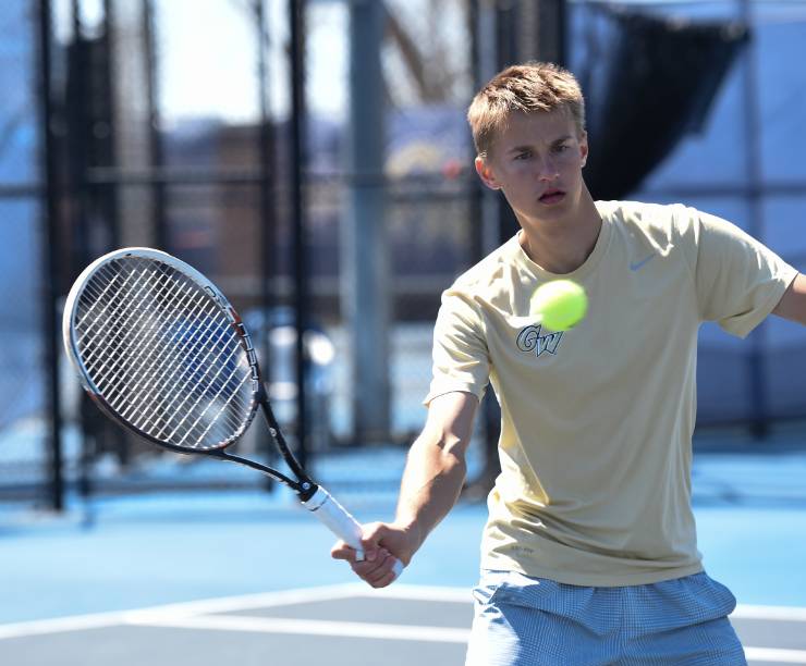 Tennis player hits ball.