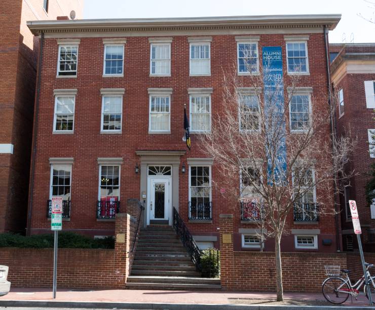 The front of Alumni House's red brick building.