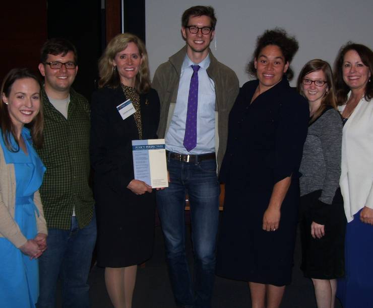 A group of students with a faculty advisor pose as a group for a photo.