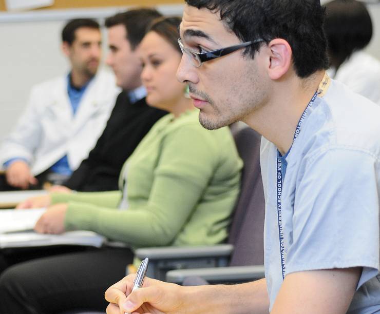 Students take notes in a classroom.