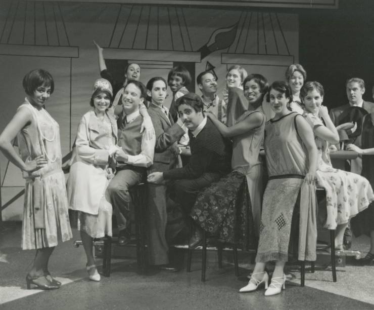 A black and white photo of student actors in 1920's costumes on stage, with actress Kerry Washington in the center.