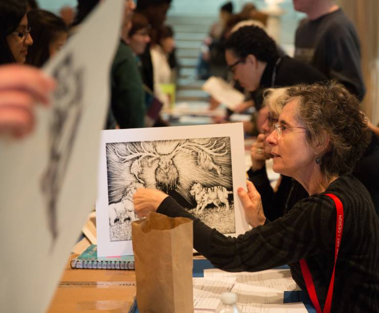 A college representative discusses a sketch with a student.