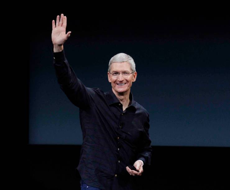 Apple CEO Tim Cook waves from a stage.