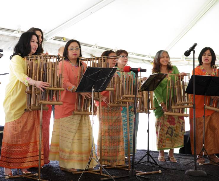 Women in traditional Indonesian clothing perform onstage.