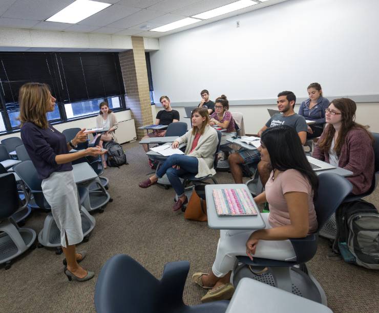 Group of students listen to teacher in class.