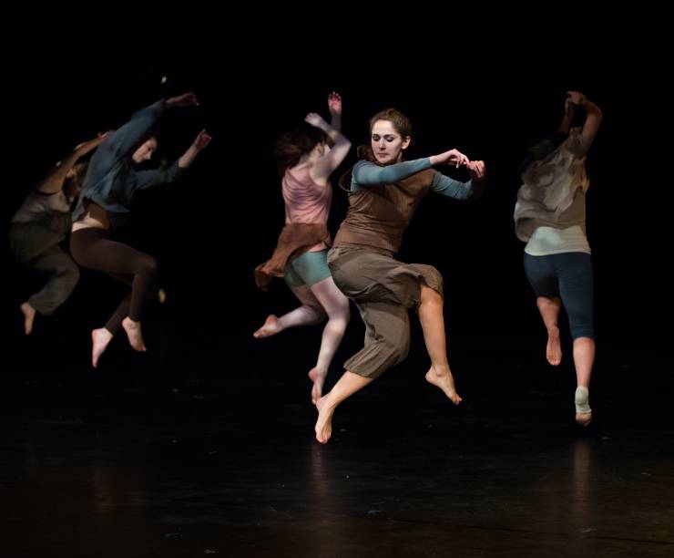 A group of dancers perform onstage.