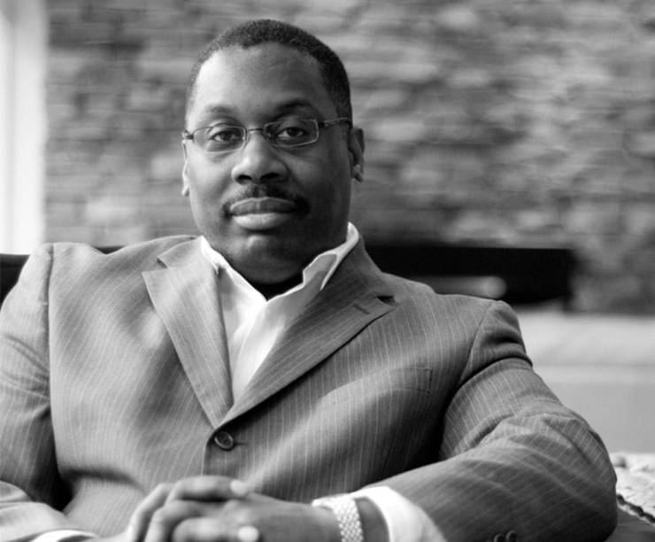 A portrait of Thomas LaVeist sitting at a table.