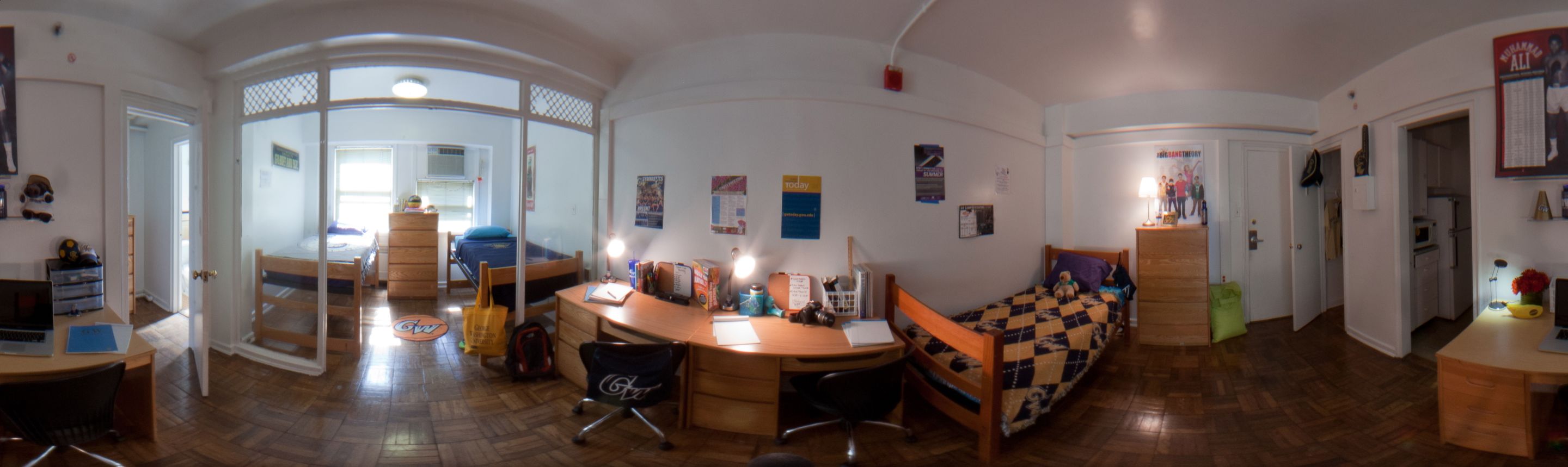 A panoramic view of a triple residence hall room.