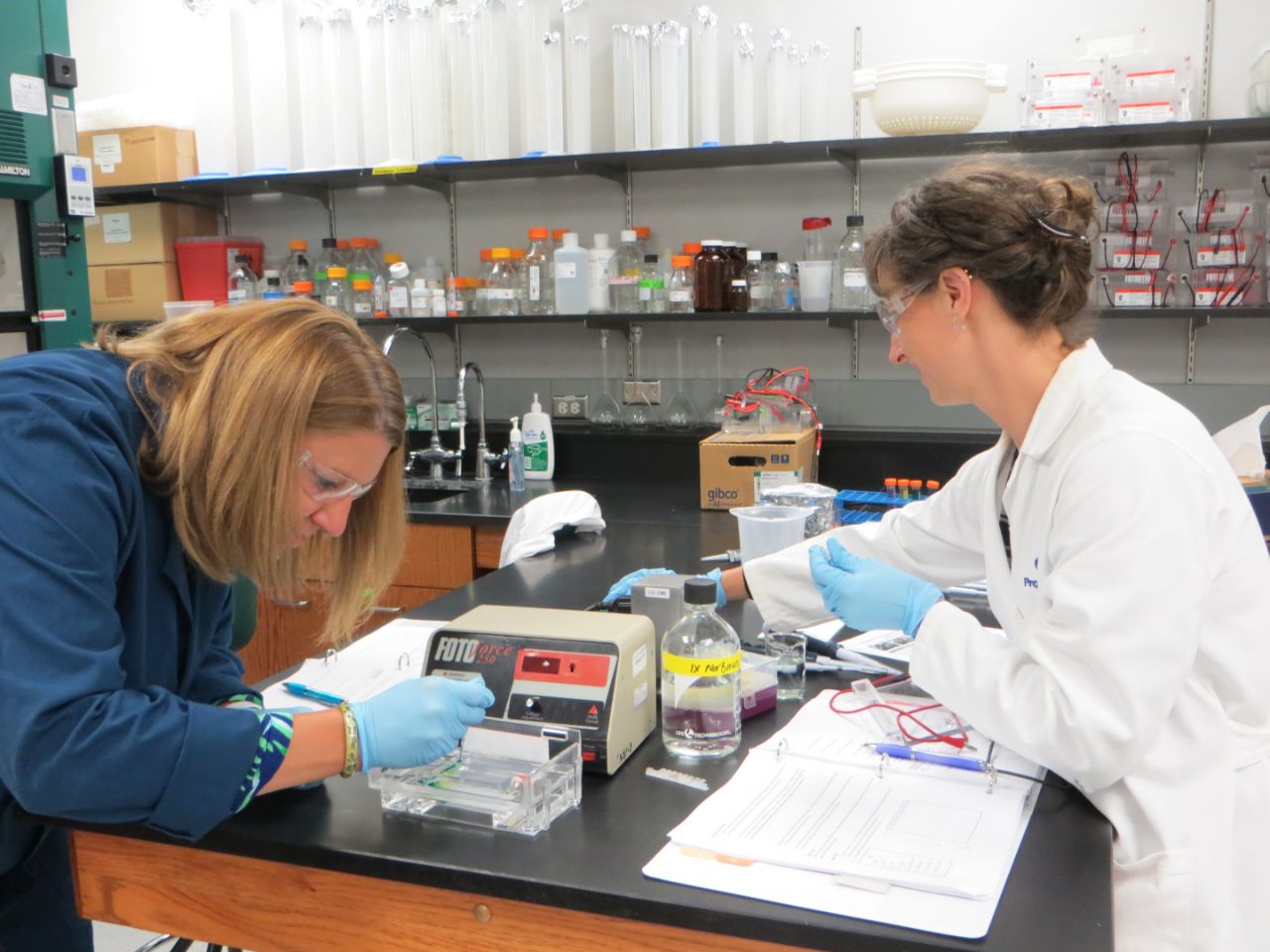 A BTCI teacher helps kids with an experiment.