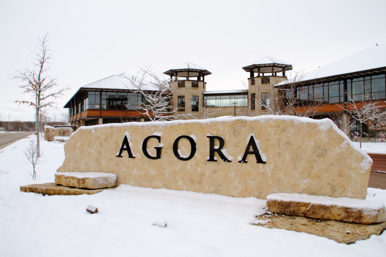 The Agora Center rock sign with snow covering it.