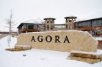 The Agora Center rock sign with snow covering it.