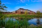 View of the Feynman Center's floor to second story ceiling glass windows from the small pond out front.