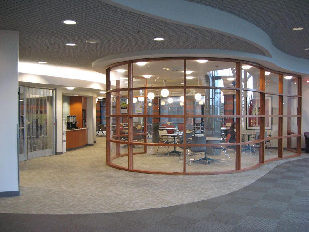 The cafeteria of the BTC, showing tables and chairs with windows to see out onto the patio.