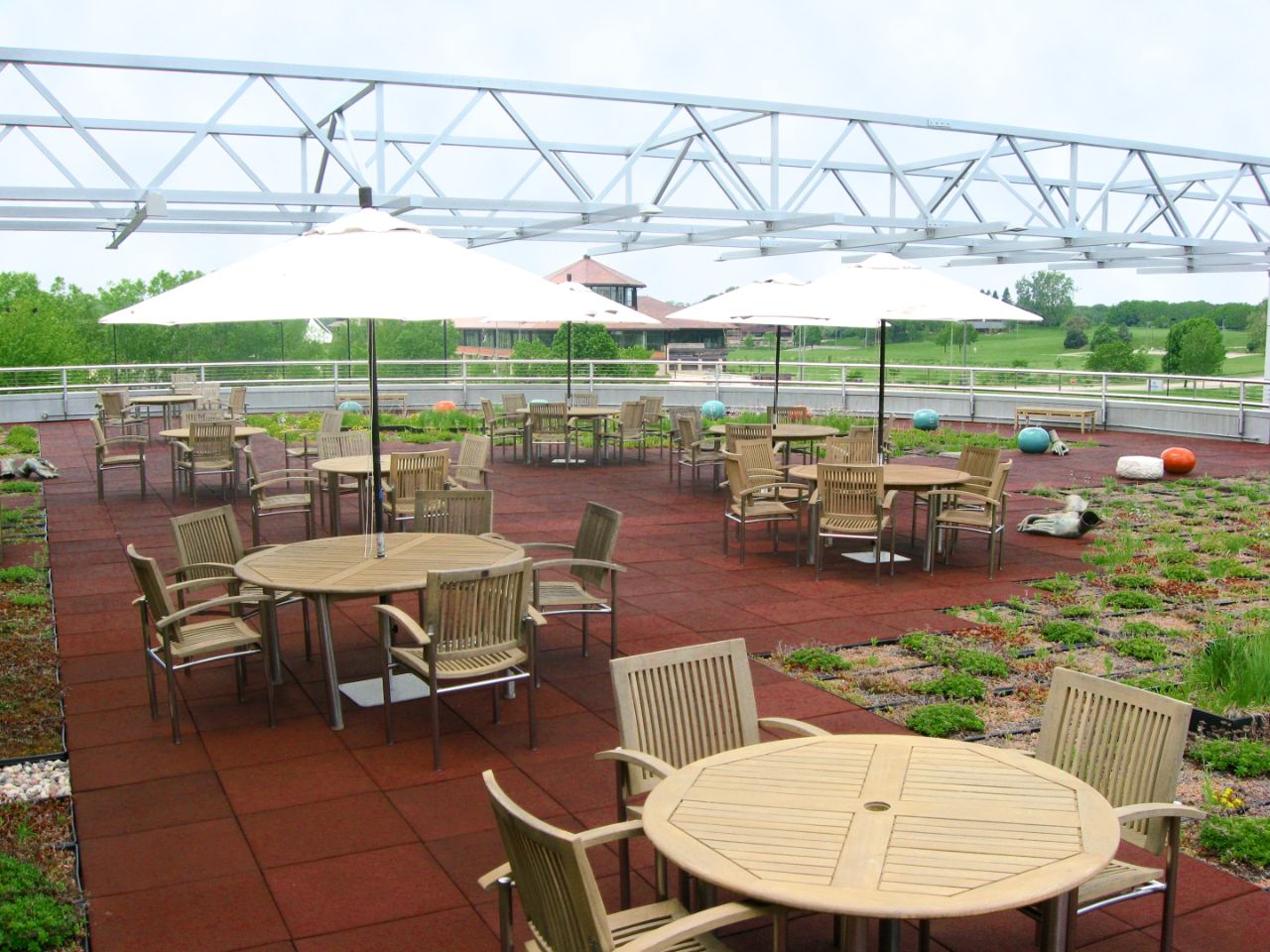 A picture of the Terrazzo, which is the second floor walk-out terrace that includes circular tables and wooden chairs for people to enjoy lunch or meetings outside.