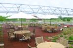 A picture of the Terrazzo, which is the second floor walk-out terrace that includes circular tables and wooden chairs for people to enjoy lunch or meetings outside.