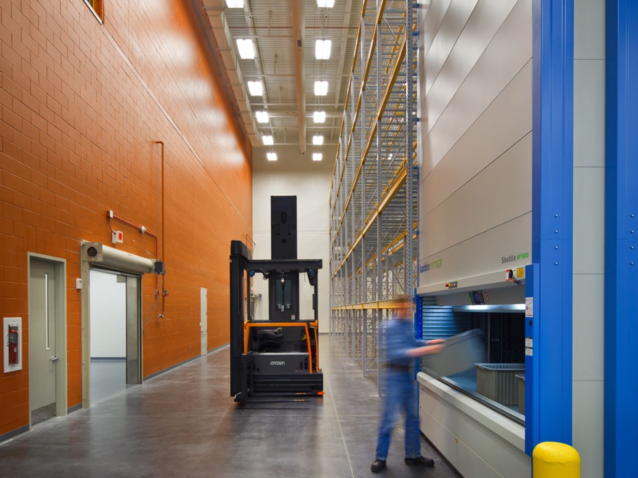 The Feynman Center's warehouse is pictured here with a forklift driver putting bins away.