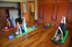 Three people laying on yoga mats practicing their yoga poses.