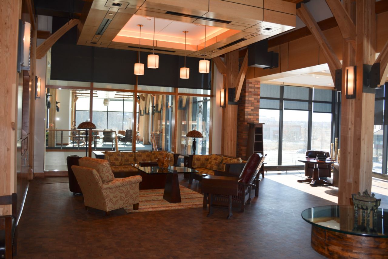 The Feynman Oasis Room is filled with furniture, two large monitors for presentations, a long board room table, a kitchenette, and a view of the prairie swale.