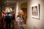 A woman admires a painting hanging on the wall of the BTC for the 2016 art show.