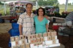 Two vendors pose for a picture at the farmer's market.