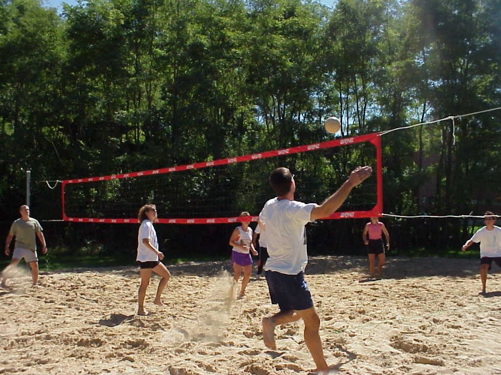 A picture of the volleyball players in a match on the volleyball courts.