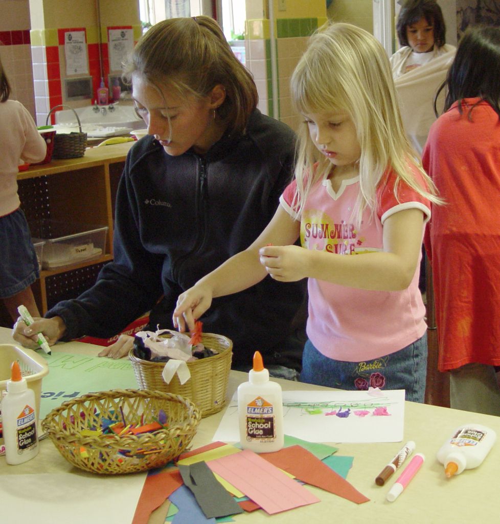 A child and her caretaker play with crafts at a table in Woods Hollow Children's Center.