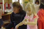 A child and her caretaker play with crafts at a table in Woods Hollow Children's Center.