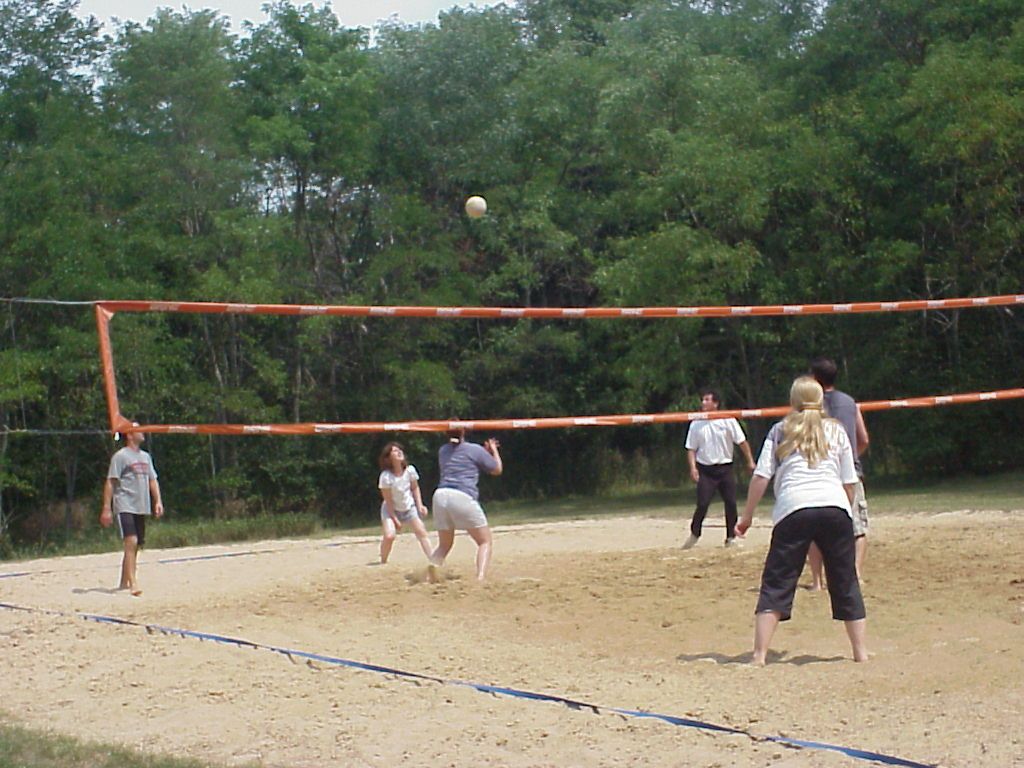 Volleyball players wait for a ball to drop