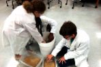 Two kids experimenting with buckets of sand.