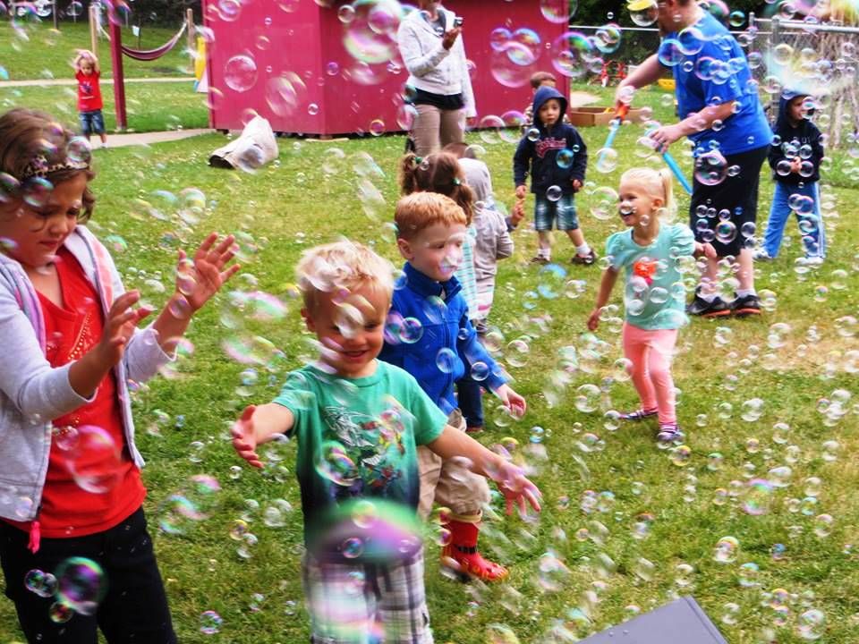 Children at Woods Hollow Children's Center play and dance in a sea of bubbles.