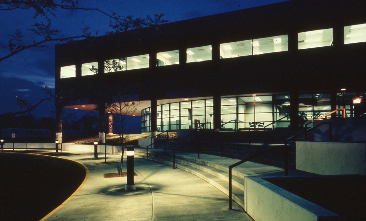 The ground lights of the RDC light up the exterior of the building at night.