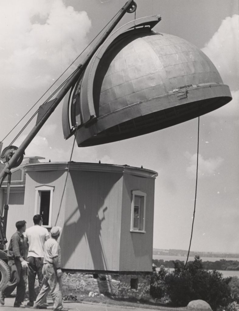 The installation of the dome for the observatory, being lowered from a crane.