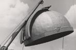 The installation of the dome for the observatory, being lowered from a crane.