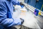 A packaging expert lifts a stack of packages out of the cryo tanks in the Kepler building.