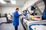 Two scientists in lab coats working in a lab with machines in the RFC.