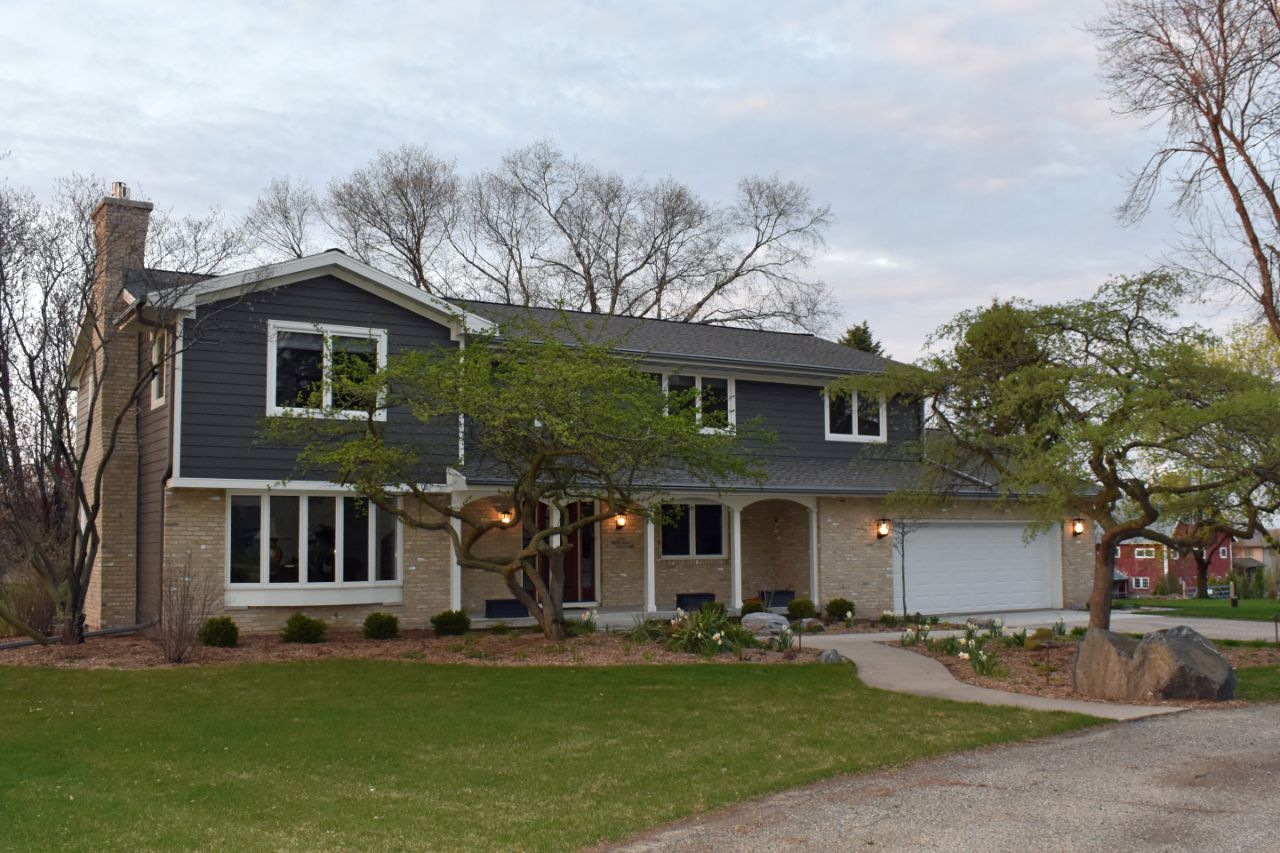 the exterior of a two story house with a chimney on the left side and garage on the right