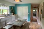 hard wood floor kitchen with a picnic table, white cupboards, blue walls