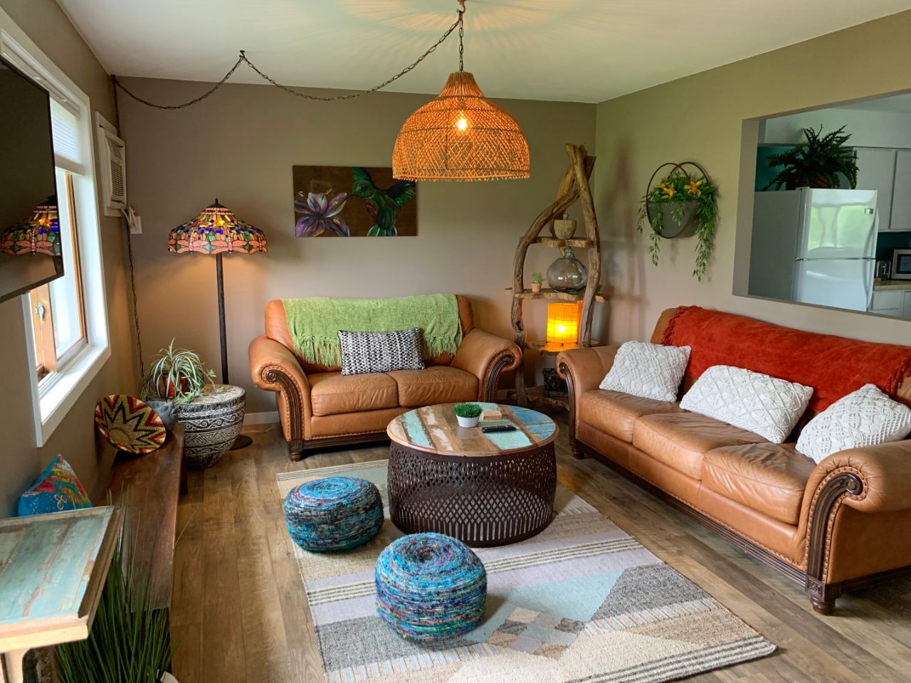 two leather couches with a circular table and geometric rug with hanging ceiling lamp