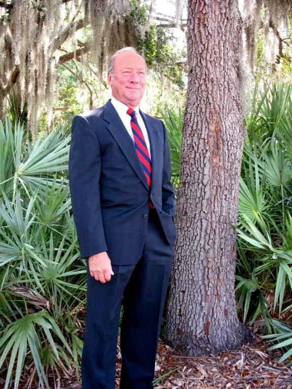 Head and shoulders photo of an older Caucasian male in a business suit.