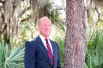 Head and shoulders photo of an older Caucasian male in a business suit.