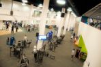 Large indoor open area has two-story ceilings and contains rows of various weight and exercise machines where students are milling around.