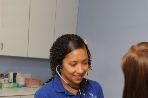 A female nursing student is taking the blood pressure of a female patient in a doctor's office.