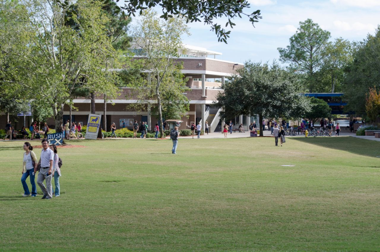 Many students walking across the campus towards the Robinson Building.