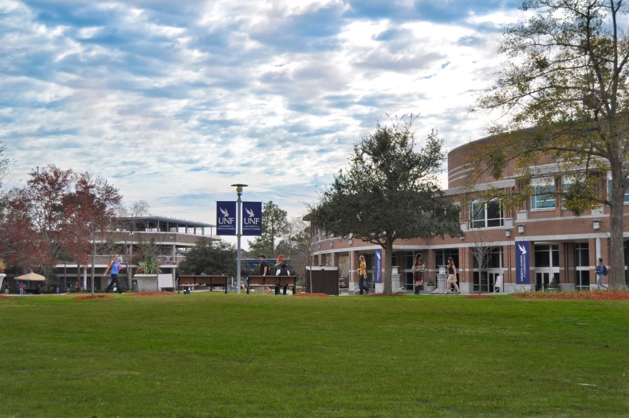 Several students walking on the side walk towards the Fine Arts Center.