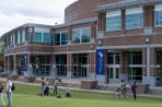 Two groups of students in front of the Fine Arts Center. The first group is hulu hooping and the other two students are talking.